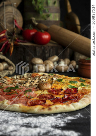 Italian Pizza Four Seasons (Pizza Quattro Stagioni) with different ingredients on the wooden table in the kitchen Italian Pizza Four Seasons (Pizza Quattro Stagioni) with different ingredients on the wooden table in the kitchen 109957534