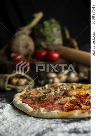 Italian Pizza Four Seasons (Pizza Quattro Stagioni) with different ingredients on the wooden table in the kitchen Italian Pizza Four Seasons (Pizza Quattro Stagioni) with different ingredients on the wooden table in the kitchen 109957542
