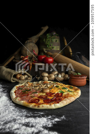 Italian Pizza Four Seasons (Pizza Quattro Stagioni) with different ingredients on the wooden table in the kitchen Italian Pizza Four Seasons (Pizza Quattro Stagioni) with different ingredients on the wooden table in the kitchen 109957595