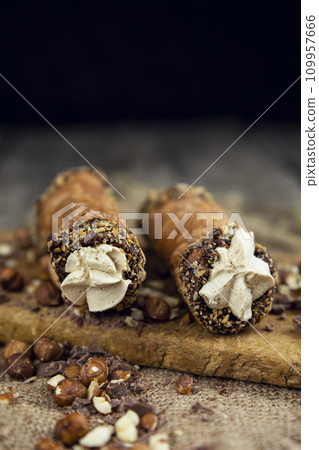 Cannoli, deep fried Italian pastry tubes with a sweet ricotta cheese, chocolate chips and hazelnuts served on a wooden board Cannoli, deep fried Italian pastry tubes with a sweet ricotta cheese, chocolate chips and hazelnuts served on a wooden board 109957666