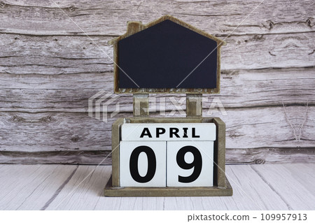 Chalkboard with April 09 date on white cube block on wooden table. Chalkboard with April 09 date on white cube block on wooden table. 109957913
