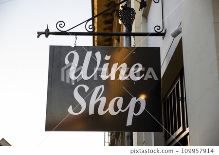 Wine shop sign hanging from old building Wine shop sign hanging from old building 109957914