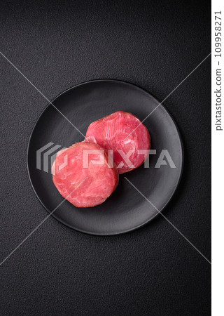 Round shape steaks of raw juicy tuna with salt and spices Round shape steaks of raw juicy tuna with salt and spices 109958271