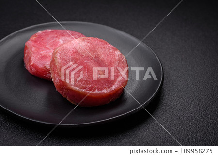 Round shape steaks of raw juicy tuna with salt and spices Round shape steaks of raw juicy tuna with salt and spices 109958275