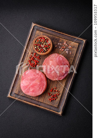 Round shape steaks of raw juicy tuna with salt and spices Round shape steaks of raw juicy tuna with salt and spices 109958317