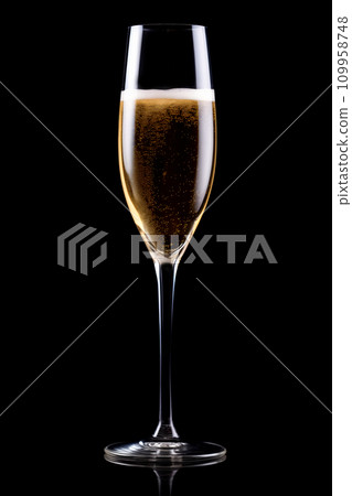A crystal-clear flute glass of champagne isolated on black background A crystal-clear flute glass of champagne isolated on black background 109958748