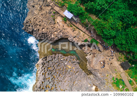 A cliff broken by the wave of the ocean. Natural azure bathing pool in the middle of the rock. A popular tourist spot on the island of Nusa Penida in Indonesia. 109960102