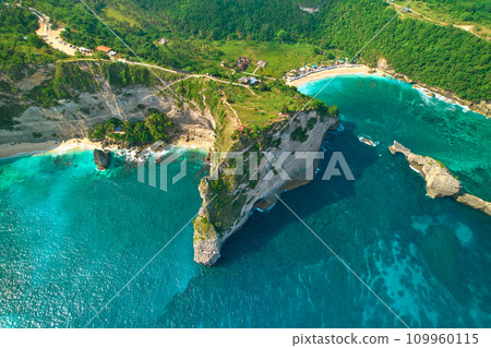 Cinematic aerial landscape shots of the beautiful island Diamond beach of Nusa Penida. Huge cliffs by the shoreline and hidden dream beaches with clear water. 109960115