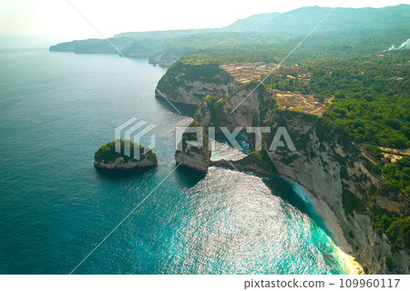 Cinematic aerial landscape shots of the beautiful island Diamond beach of Nusa Penida. Huge cliffs by the shoreline and hidden dream beaches with clear water. Cinematic aerial landscape shots of the beautiful island Diamond beach of Nusa Penida. Huge cliffs by the shoreline and hidden dream beaches with clear water. 109960117