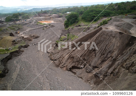 A stone quarry in Indonesia. Large equipment such as bulldozers and dump trucks are working on the site. 109960126