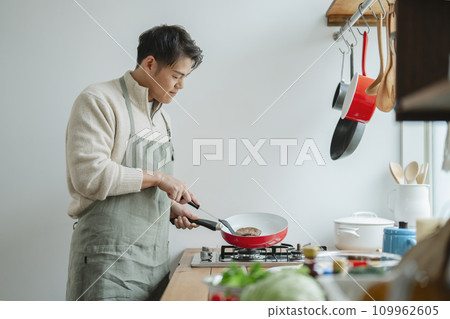 A man in his 30s cooking 109962605