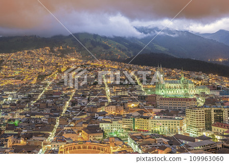 Bird eyes view at golden hour of the illuminated colonial center of Quito with the Basilique of the National Vow 109963060