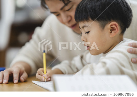 Profile of a first grade boy studying, image of a father watching his studies Profile of a first grade boy studying, image of a father watching his studies 109967096