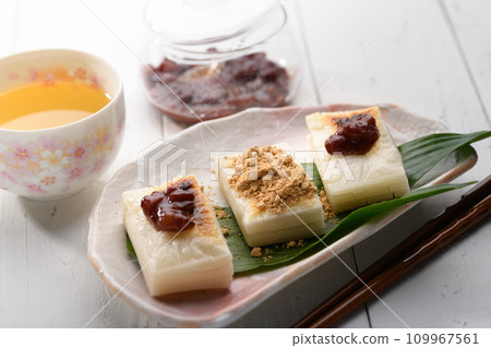 Freshly baked cut mochi topped with red bean paste and soybean flour 109967561