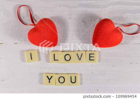 Red hearts and "I Love You" text on white wooden background Red hearts and "I Love You" text on white wooden background 109969454
