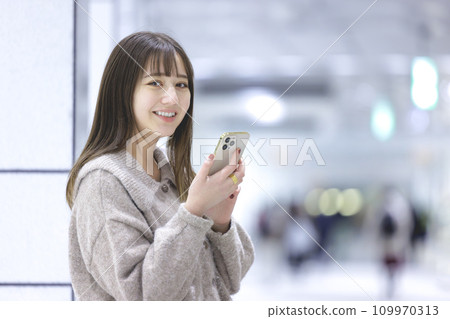 A young woman operating a smartphone A young woman operating a smartphone 109970313