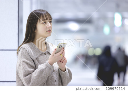 一個操作智能手機的年輕女子 一個操作智能手機的年輕女子 109970314
