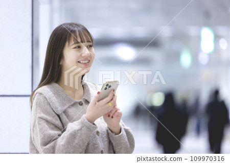 一個操作智能手機的年輕女子 一個操作智能手機的年輕女子 109970316