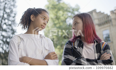 Two girls looking at each other with hostility, bullying, socialization problem at school Two girls looking at each other with hostility, bullying, socialization problem at school 109970882