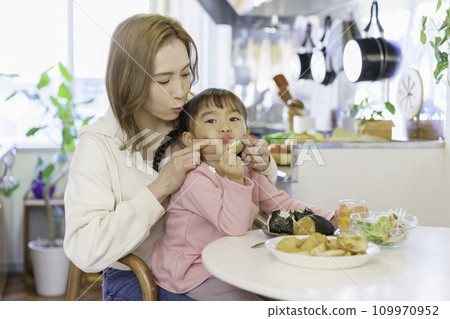 年輕的棕髮媽媽和她 4 歲的女孩在廚房吃飯 109970952