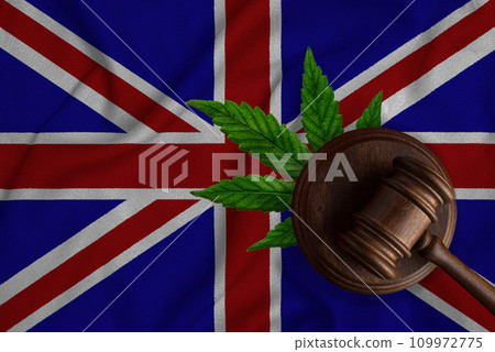 Flag of Great Britain and justice wooden gavel with cannabis leaf. Illegal growth of cannabis plant and drugs spreading. Flag of Great Britain and justice wooden gavel with cannabis leaf. Illegal growth of cannabis plant and drugs spreading. 109972775