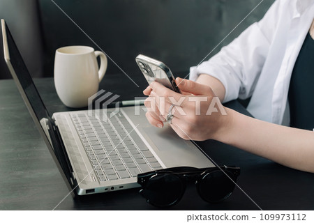 Professional Businesswomen Multitasking with Laptops and Smartphones in Modern Office. Diverse Professional Businesswomen Multitasking with Laptops and Smartphones in Modern Office. Diverse 109973112