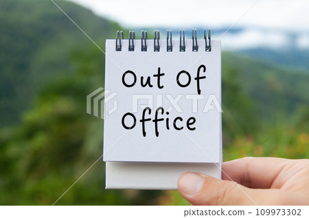 Hand holding notepad with Out Of Office text with nature background Hand holding notepad with Out Of Office text with nature background 109973302