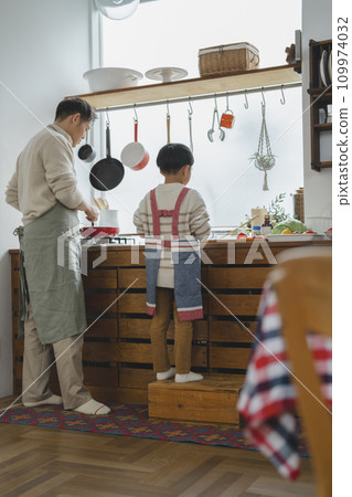 Father and son cooking, rear view Father and son cooking, rear view 109974032