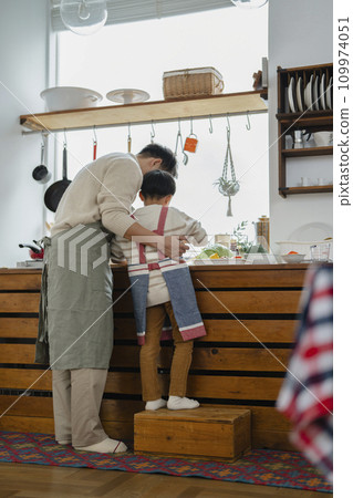 Parent and child cooking, father in his 30s and son in elementary school, back view Parent and child cooking, father in his 30s and son in elementary school, back view 109974051