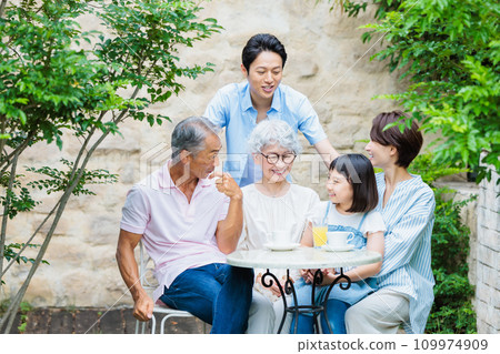 Happy family relaxing in the garden of their home 109974909