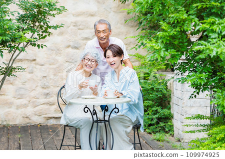 Happy family relaxing in the garden of their home Happy family relaxing in the garden of their home 109974925