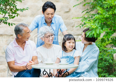 Happy family relaxing in the garden of their home 109974926