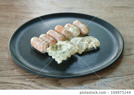 steamed Ravioli with pork sausage dressing carbonara white sauce topping chop seaweed on plate steamed Ravioli with pork sausage dressing carbonara white sauce topping chop seaweed on plate 109975244