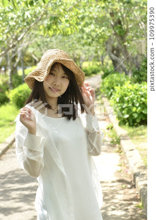 Fresh green park and young woman wearing a straw hat Fresh green park and young woman wearing a straw hat 109975390