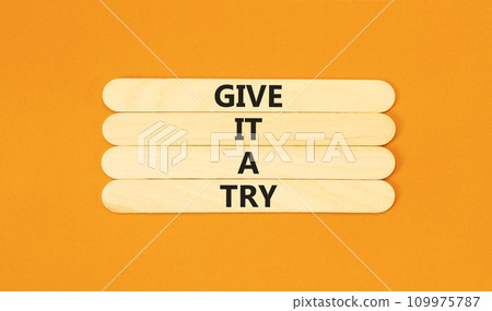 Give it a try symbol. Concept word Give it a try on beautiful wooden stick. Beautiful orange table orange background. Business give it a try concept. Copy space. 109975787