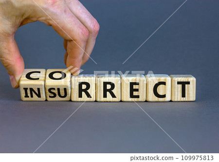 Correct vs insurrect symbol. Businessman hand turns wooden cubes and changes the word 'insurrect' to 'correct'. Beautiful grey background, copy space. Business, correct vs insurrect concept. 109975813