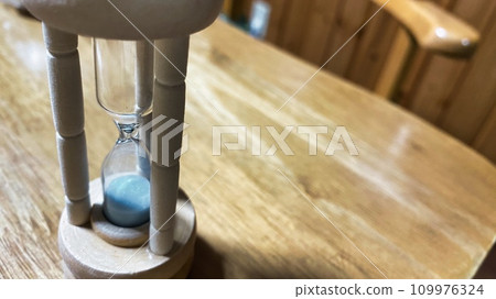 hourglass on the desk hourglass on the desk 109976324