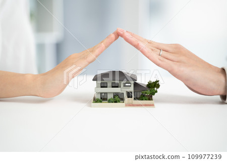 The hands of a couple protecting their home The hands of a couple protecting their home 109977239