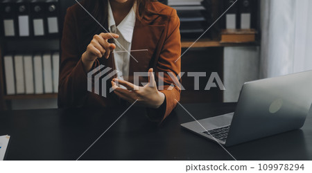 Asian Businesswoman Using laptop computer and working at office with calculator document on desk, doing planning analyzing the financial report, business plan investment, finance analysis concept. Asian Businesswoman Using laptop computer and working at office with calculator document on desk, doing planning analyzing the financial report, business plan investment, finance analysis concept. 109978294