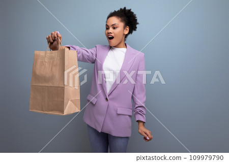young pretty cute hispanic business woman with curly hair in a lilac jacket received delivery in an young pretty cute hispanic business woman with curly hair in a lilac jacket received delivery in an 109979790