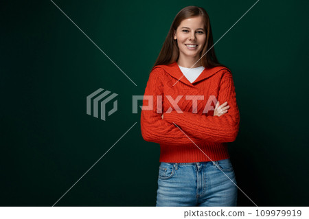 Successful Caucasian woman with brown hair wearing a red sweater on a green background 109979919