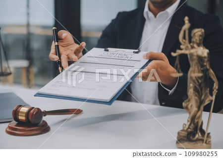 Business and lawyers discussing contract papers with brass scale on desk in office. Law, legal services, advice, justice and law concept picture with film grain effect Business and lawyers discussing contract papers with brass scale on desk in office. Law, legal services, advice, justice and law concept picture with film grain effect 109980255