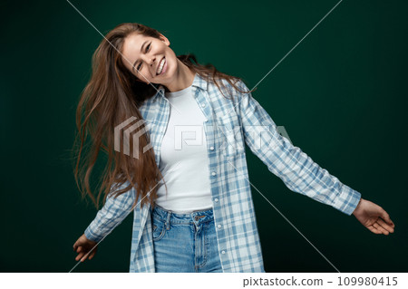 Portrait of a well-groomed young lady straightening her natural brown hair Portrait of a well-groomed young lady straightening her natural brown hair 109980415