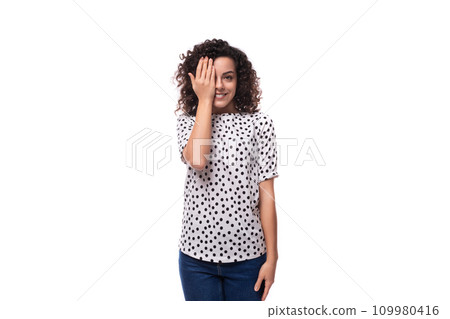 young stylish woman with curly hair dressed in a blouse with polka dots smiles and feels happy young stylish woman with curly hair dressed in a blouse with polka dots smiles and feels happy 109980416