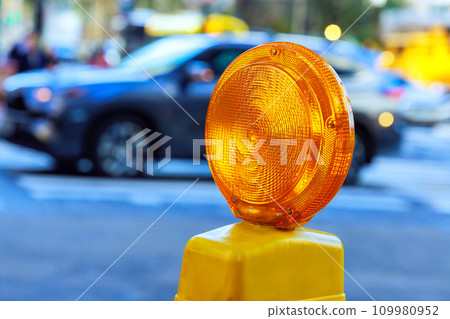 Detailed yellow warning orange construction light mounted on barricade intended for purpose of warning construction workers Detailed yellow warning orange construction light mounted on barricade intended for purpose of warning construction workers 109980952