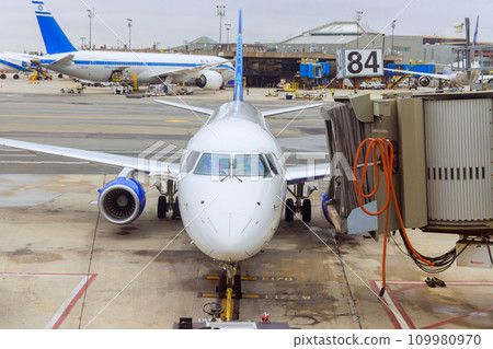 At boarding gate bridge ground services are providing services to passenger planes before their next takeoff in airport At boarding gate bridge ground services are providing services to passenger planes before their next takeoff in airport 109980970