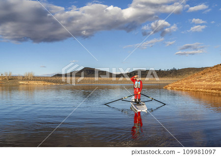 Senior male rower is standing in a coastal rowing shell - Horsetooth Reservoir in fall or winter scenery in northern Colorado. 109981097