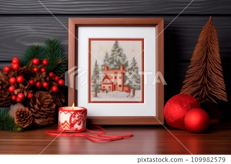 A framed embroidered christmas card with ornaments and candles on wooden table. Winter background with pine twigs A framed embroidered christmas card with ornaments and candles on wooden table. Winter background with pine twigs 109982579