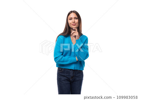 portrait of a young beautiful slim brunette woman dressed in a blue cardigan on a white background 109983058