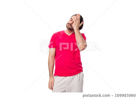 young pleasant slender brunette man with a cool haircut is dressed in a red T-shirt covered his face 109983060